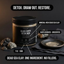 A jar of Better Human Earth Co Black Earth Detox Mud is displayed on a dark surface with callout labels pointing to key product features, including mineral-rich dead sea clay and earth-derived unscented formula. The scene includes small rocks, a cloth, and a small dish with mud, under the headline 'DETOX.