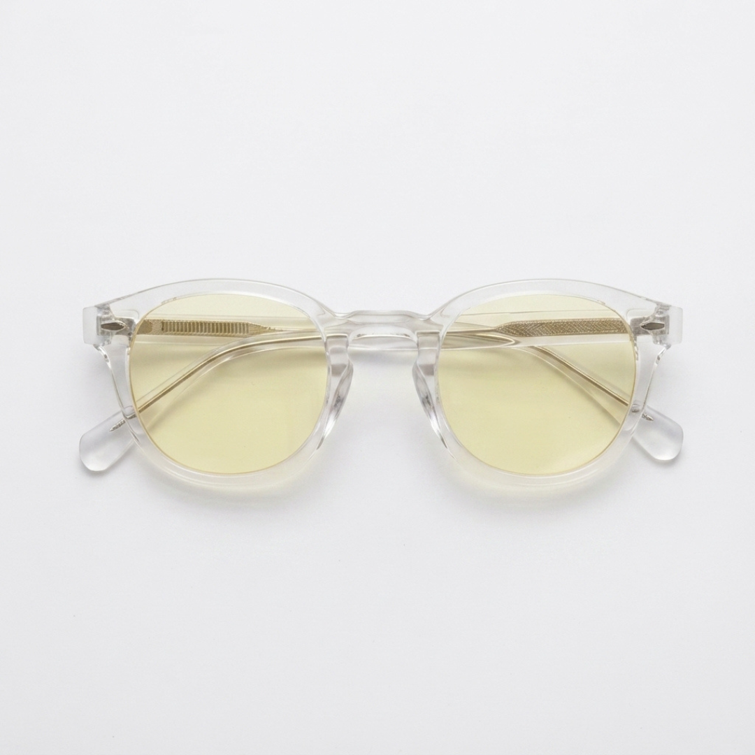 Clear acetate round-frame sunglasses with pale yellow tinted lenses, displayed on a clean white background.