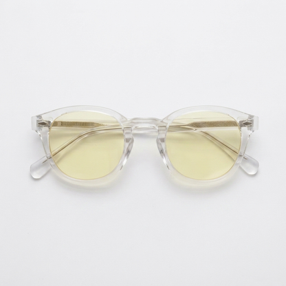 Clear acetate round-frame sunglasses with pale yellow tinted lenses, displayed on a clean white background.