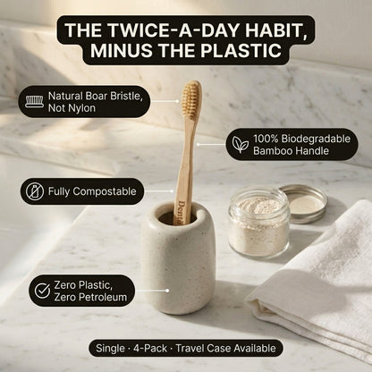 A bamboo toothbrush with a natural wood handle stands in a speckled ceramic holder on a marble surface. Text callouts describe eco-friendly features: natural boar bristle, 100% biodegradable bamboo handle, fully compostable, and zero plastic.