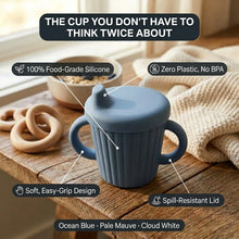 A blue silicone baby cup with side handles and a spout lid sits on a wooden table in a styled setting with a knit blanket, wooden teething rings, and a bowl in the background. Text overlays highlight product features like food-grade silicone, zero plastic, spill-resistant lid, and soft easy-grip design.